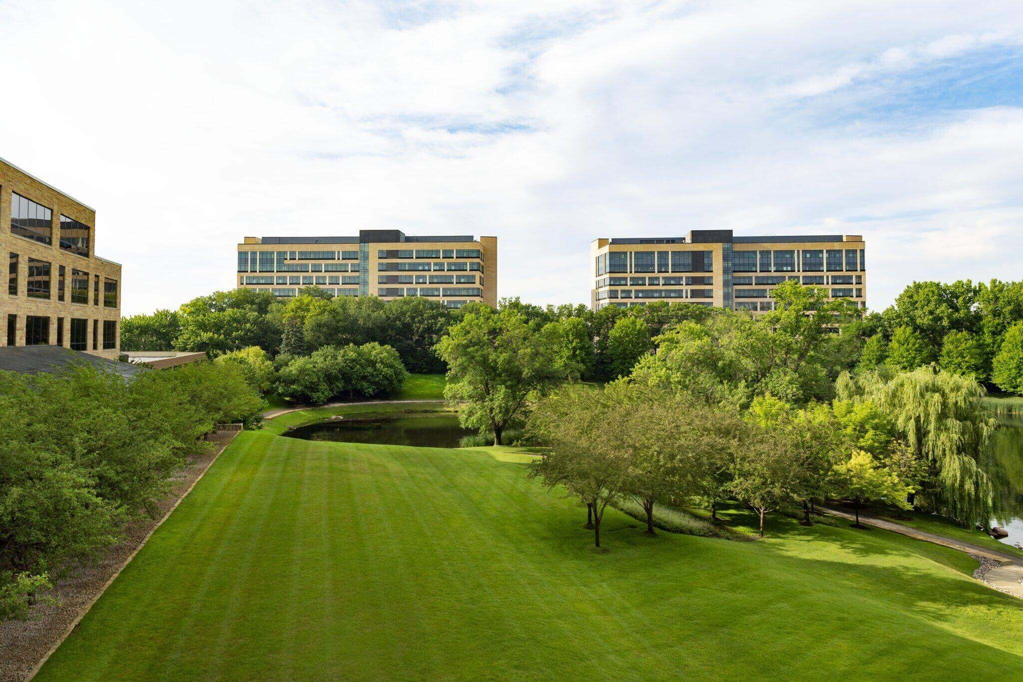 A modern corporate campus with green spaces and trees.